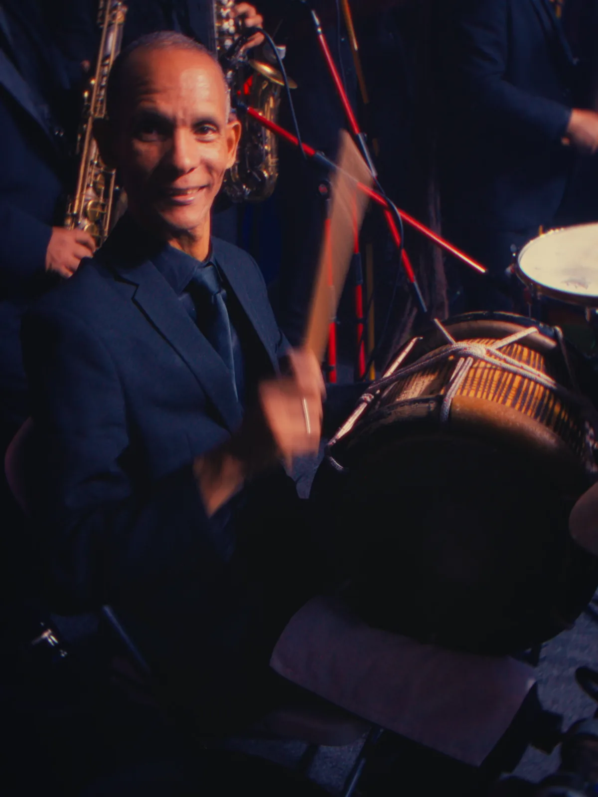 Sección de vientos y percusión de la orquesta en tarima.